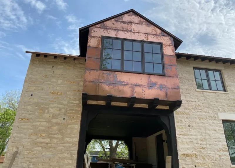 Copper metal panel facade on a stone building for Roof Repair in Guilford